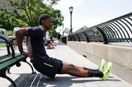 man doing tricep dips from a bench